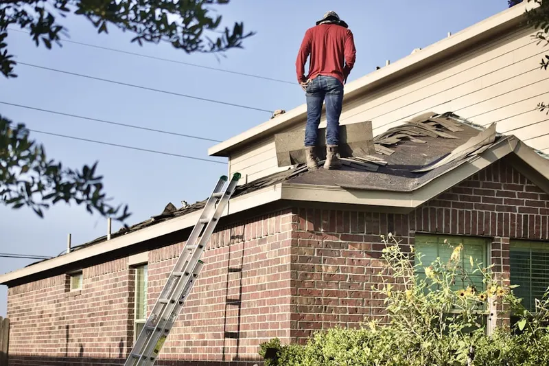 Professional roofer working on a residential roof in Image